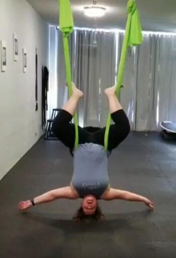 photo of Tracie Thompson doing an inverted aerial yoga pose